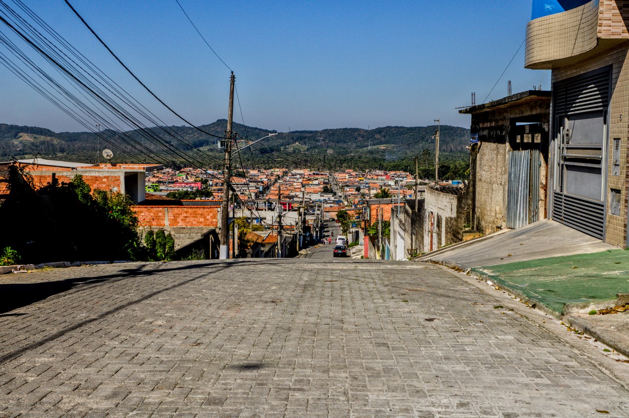 Bairro de Vargem Grande no interior da Cratera de Colônia. Vista de bairro periférico com borda de cratera ao fundo.