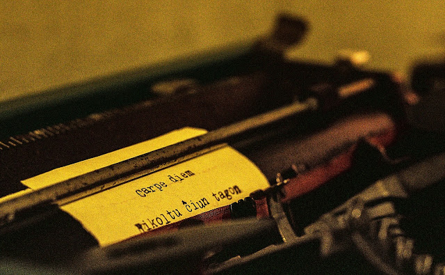 Primeiro plano de papel em máquina de escrever com a frase latina Carpe Diem e, abaixo, em Esperanto, sua tradução, Rikoltu cxiun tagon