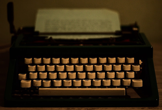 Vista frontal de máquina de escrever com papel preenchido com texto até a metade